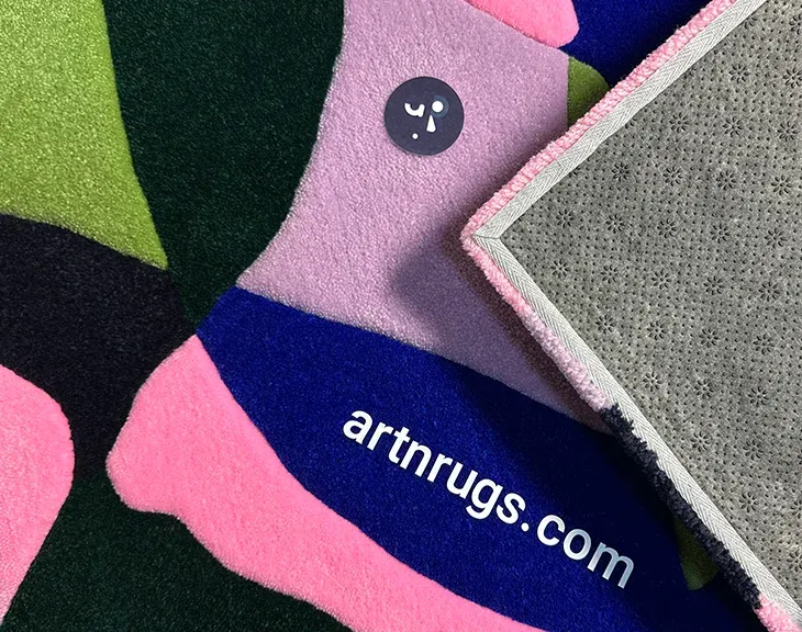 Close-up of blue, pink and green acrylic pile on a hand-tufted rug