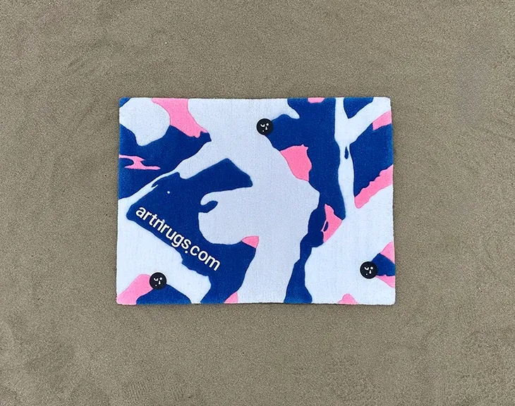 Distant view of the blue, cream and pink rug on gray carpet.