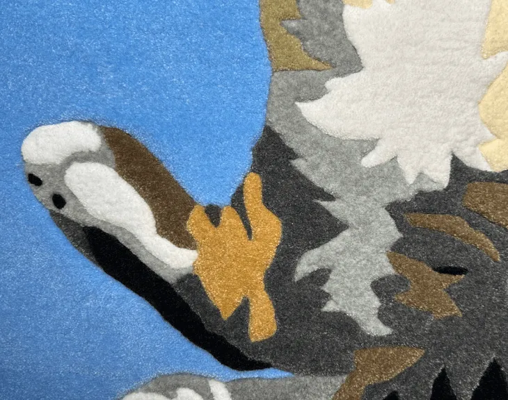 Top view of the full-body cat portrait rug on a wooden floor.