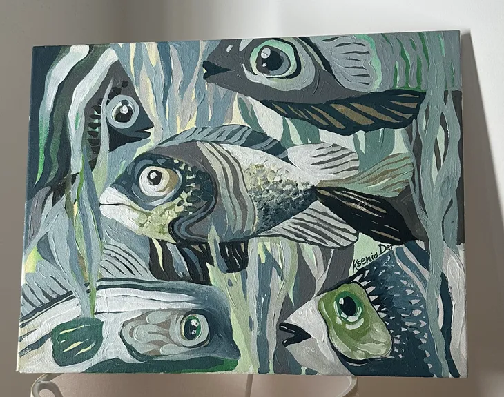 Close view of fish among blue and green aquatic plants.